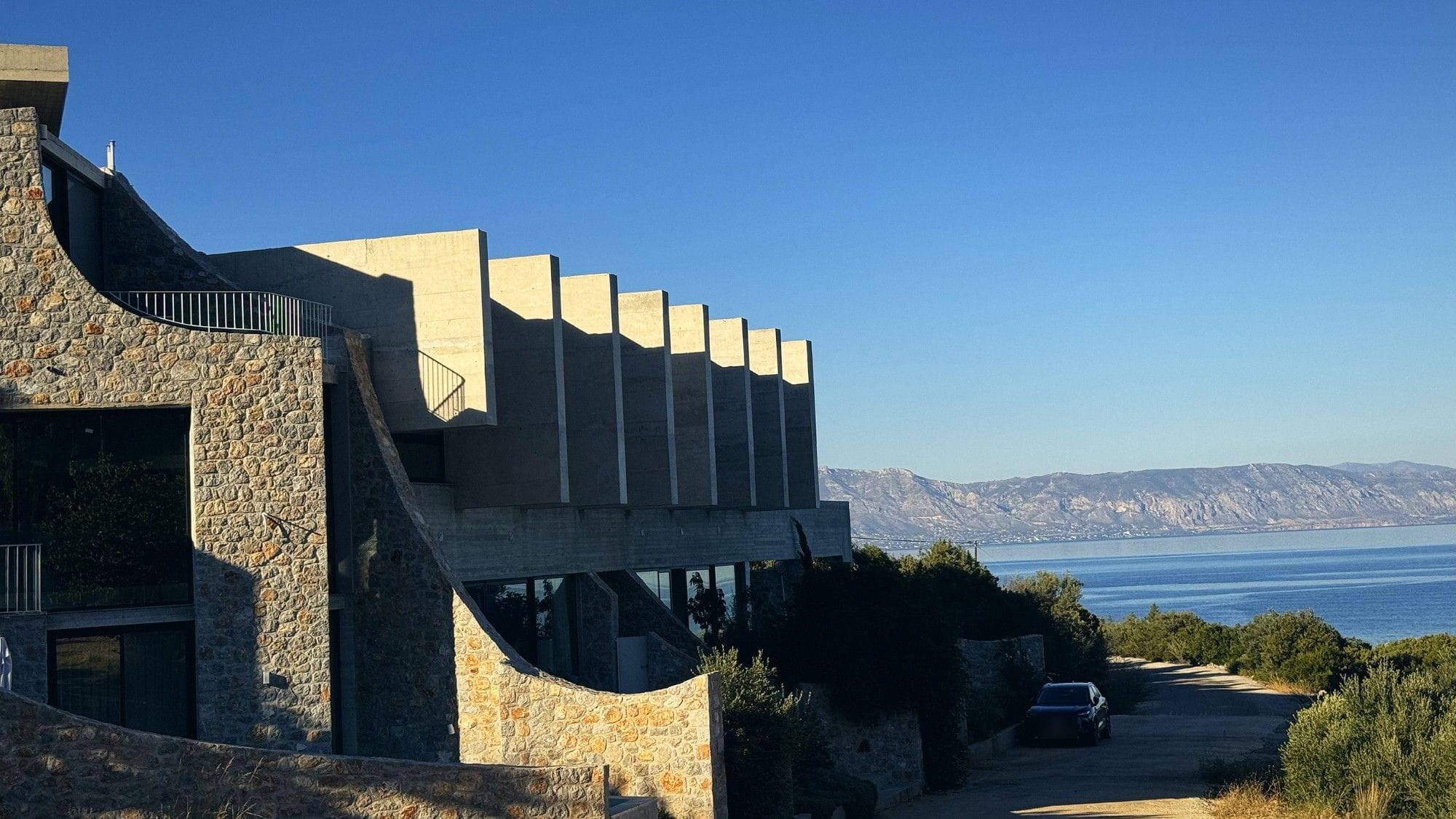 Κατοικίες από πέτρα και εμφανές σκυρόδεμα με θέα στη θάλασσα στο Αμόνι Κορινθίας — έργο των Αφών Πλεπαράκου